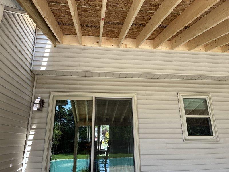 Installed four customer-provided recessed can lights and one customer-provided ceiling fan in covered patio area with exposed ceiling joists. Completed all electrical connections, secured fixtures to structural framing, and verified proper operation of all lighting and fan controls.
