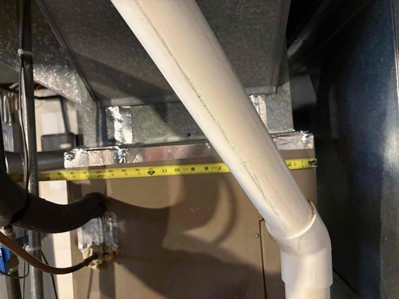 Conducted comprehensive assessment of 32-year-old air conditioning system in residential basement mechanical room. Evaluated existing HVAC equipment configuration including furnace/air handler unit, associated ductwork, and drainage systems to prepare multiple replacement options. Documented equipment specifications, spatial constraints, and existing infrastructure including overhead ductwork routing, copper refrigerant lines, and PVC condensate drainage. Measured clearances and access points to determine optimal replacement unit sizing and installation requirements for aging system reaching end of service life.