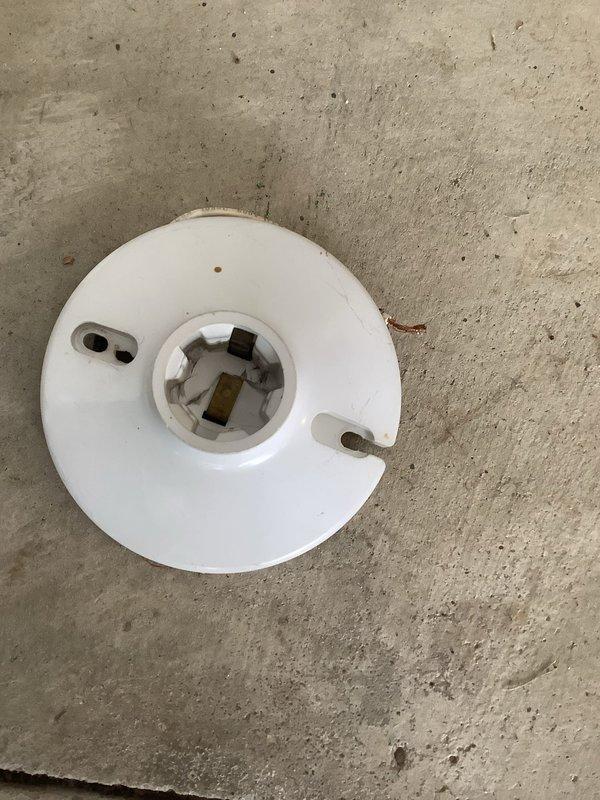 Responded to service call for non-functioning garage light fixture. Customer had already attempted to replace bulbs with no success, indicating fixture failure. Upon inspection, diagnosed faulty ceramic light socket assembly in ceiling-mounted fixture. Removed defective porcelain lamp holder from recessed ceiling fixture and replaced with new socket assembly. Verified proper electrical connections, tested fixture operation, and confirmed restored functionality. Garage lighting now operating normally.