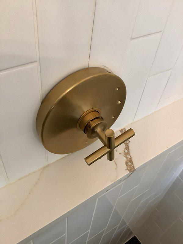 Responded to low water pressure complaint following bathroom renovation with new Kohler shower valve installation. Issue presented as normal pressure with cold water but complete loss of pressure when mixing to warm temperature. Inspected shower valve assembly and identified improperly installed or defective pressure-balancing cartridge within the Kohler trim. Removed decorative escutcheon and cross-handle trim to access valve body. Extracted cartridge and found debris restriction affecting hot water ports, preventing proper water flow during temperature mixing. Cleaned cartridge ports, verified proper orientation, and reinstalled with correct seating position. Tested system through full temperature range and confirmed restoration of normal water pressure at all temperature settings. Reassembled trim components and verified proper operation of pressure-balancing function.