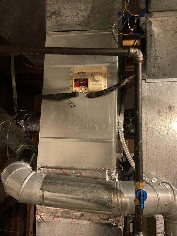 Replaced defective humidistat control on Aprilaire humidifier system mounted to air handler unit. Removed old control, installed new humidistat, verified proper wiring connections, and tested system operation to ensure proper humidity control functionality.