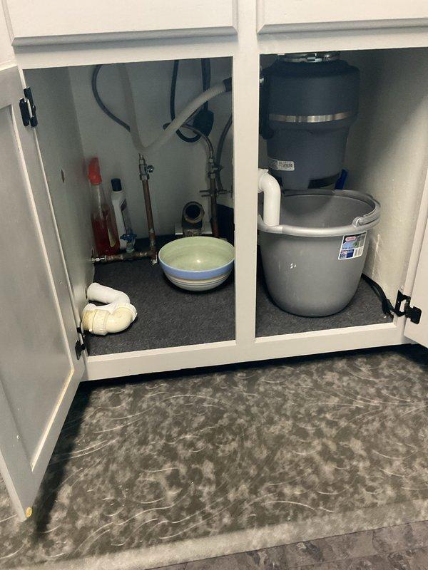 Responded to kitchen sink drainage issue. Upon inspection, identified complete blockage in drain line beyond P-trap assembly. Accessed plumbing system through cabinet base and confirmed obstruction was located downstream of trap, requiring extended cable augering. Successfully cleared blockage using professional drain snake equipment, restoring full drainage capacity. Tested system with water flow to verify complete clearance and proper drainage speed. Left work area clean with all plumbing connections secure and leak-free.