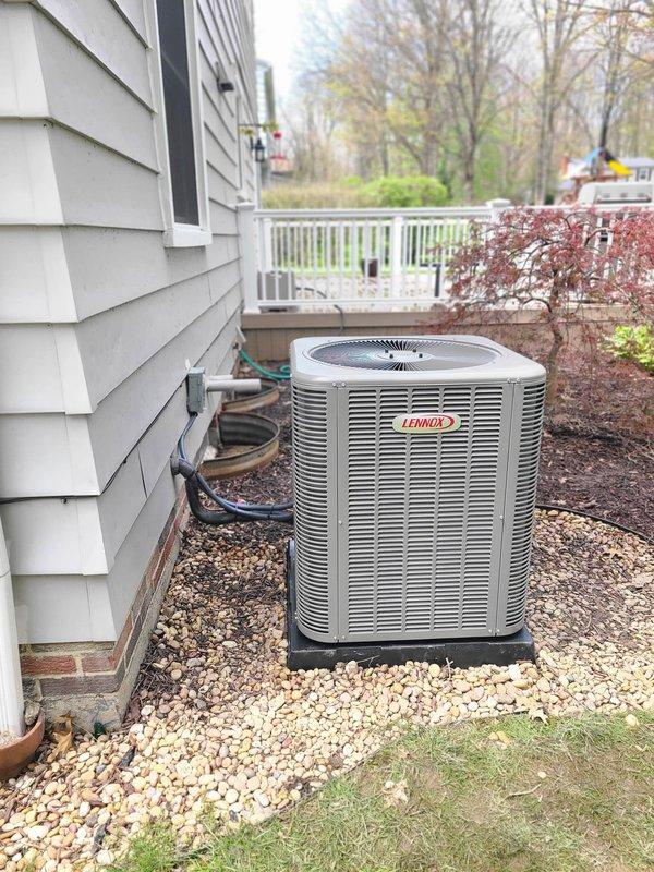 Completed installation of new Lennox air conditioning system with outdoor condensing unit and evaporator coil. Unit was positioned on composite base pad over prepared gravel bed adjacent to residence, with refrigerant lines properly insulated and routed along exterior wall to indoor coil location. System startup performed, refrigerant charge verified, and all electrical connections secured per manufacturer specifications.