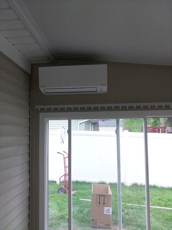 Completed installation of a single-head Daikin ductless mini-split system. Mounted outdoor condenser unit on elevated pad with proper support blocks against exterior wall, installed indoor wall-mounted air handler near ceiling, and ran refrigerant lines with proper insulation from condenser to indoor unit. System tested and operational upon completion.