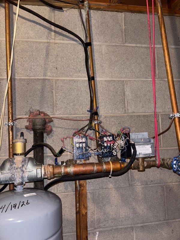 Responded to a failed electrical inspection by correcting multiple code violations in the basement utility area. Removed paint contamination from the water line grounding connection, installed proper bonding jumper between boiler supply and return lines, and relocated the grounding electrode conductor from the sub-panel to the main service panel per NEC requirements. All corrections verified and installation brought into compliance with current electrical code standards.