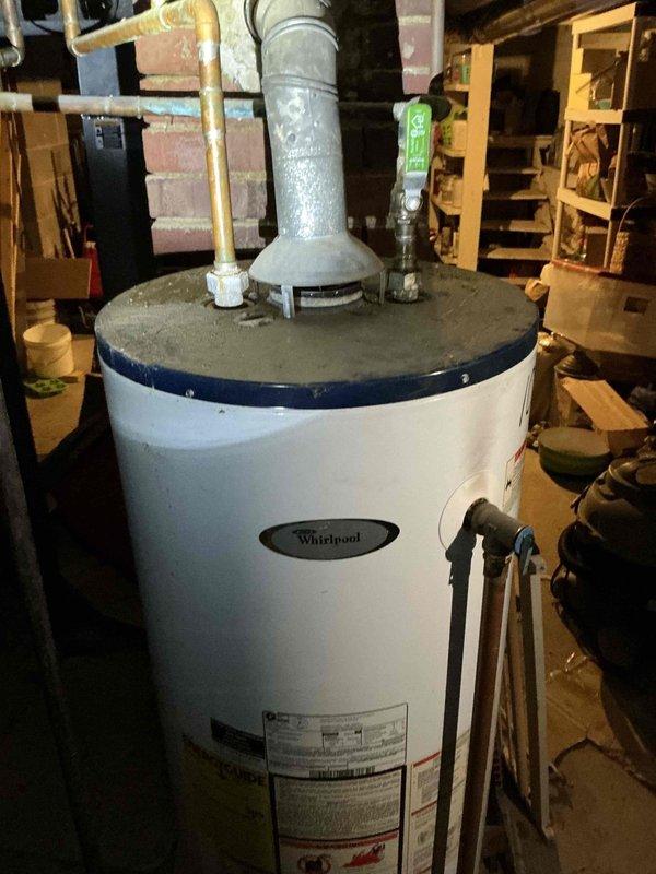 Provided comprehensive replacement estimates for aging HVAC system including outdoor air conditioning condenser unit and Whirlpool water heater, both exceeding 15 years of service life. Documented existing equipment conditions through detailed photography showing weathered AC unit with algae growth on concrete pad and residential water heater installation in basement utility area. Generated multiple quote options for complete system replacement of furnace, air conditioning unit, and hot water heater.