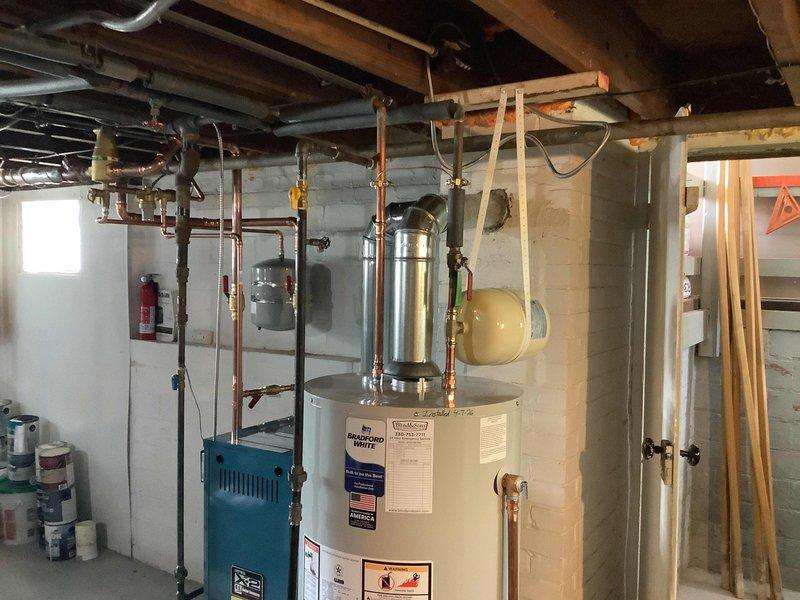 Installation failed initial inspection due to improper expansion tank support—both tanks were supported only by their connected piping rather than approved mounting brackets as required by code. Work placed on hold pending receipt of proper support hardware, with follow-up appointment scheduled for bracket installation and re-inspection once parts arrive.