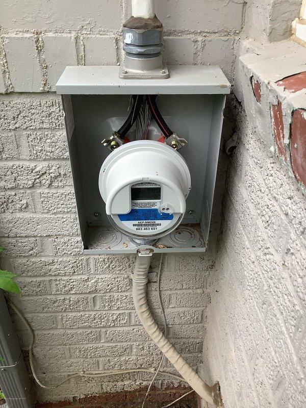 Responded to service call for water intrusion into electrical panel. Upon inspection, identified moisture entry point at exterior meter enclosure where weatherhead conduit penetrates the building envelope. Examined electrical service equipment and confirmed water had compromised panel integrity, creating potential safety hazard. Documented conditions with photographs showing exterior meter installation on weathered brick wall with inadequate sealing at conduit entry point, as well as interior utility area with plumbing equipment in proximity to electrical service. Provided professional assessment and recommendations for proper weatherproofing of service entrance conduit and evaluation of panel replacement due to water damage.
