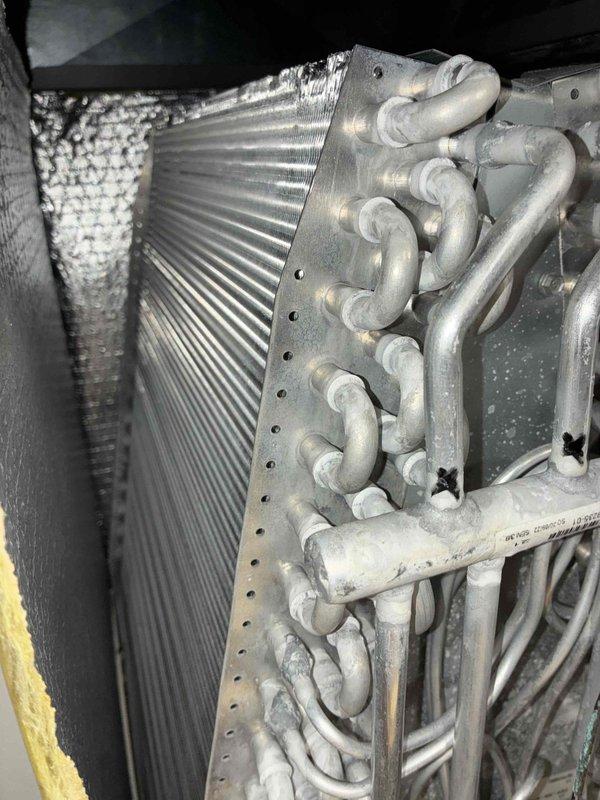 Completed scheduled cooling maintenance visit on 2-year-old air conditioning system. Performed comprehensive inspection of evaporator coil assembly, verifying fin condition and refrigerant line connections. Coil fins appeared clean and intact with no significant debris accumulation. Inspected air filter and documented substantial dust and lint buildup requiring attention. All accessible components photographed for maintenance records. System operational at time of service.