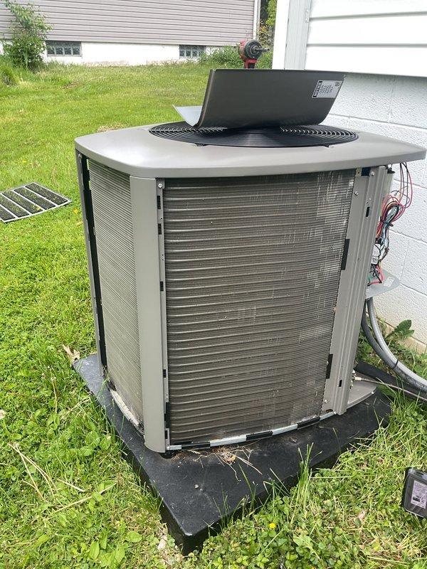 Completed routine maintenance inspection on 2-year-old residential air conditioning system. Performed visual assessment of outdoor condenser unit, confirmed proper installation on platform, verified refrigerant line connections, and documented equipment condition with all components operating within normal parameters.