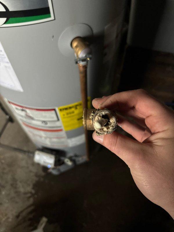 Replaced heavily corroded temperature and pressure relief valve on A.O. Smith water heater due to extensive mineral buildup and scale accumulation that compromised the valve's functionality. Additionally, installed new closet bolts and wax ring on toilet to restore proper seal and eliminate leakage at the base fixture.