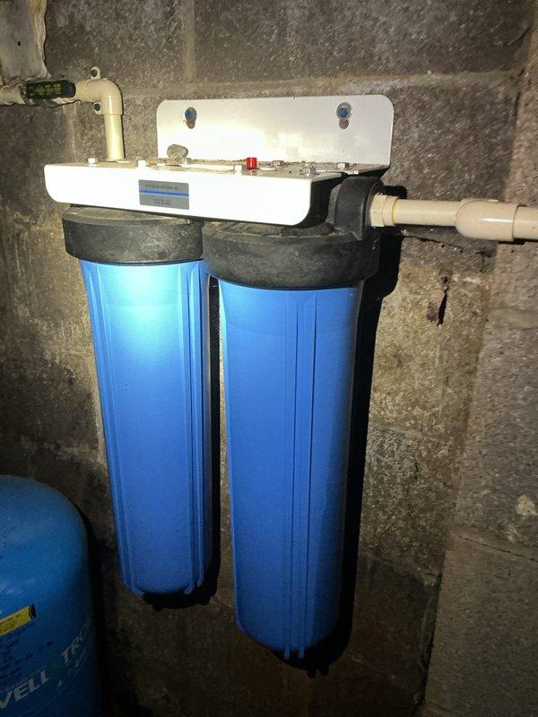 Completed outdoor spigot replacement and installed new water softener filter on existing 8-year-old Well-X-Trol system. Verified proper operation of dual-stage whole-house filtration system with pressure gauge reading within normal parameters, and confirmed water heater connections and plumbing infrastructure remained secure throughout the service work.