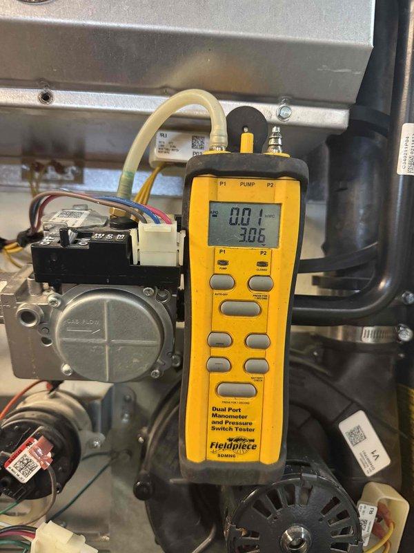 Responded to no-heat call on 11-year-old furnace blowing cold air. Upon arrival, performed diagnostic testing of gas valve and pressure switch operation using manometer to measure pressure differentials within the system. Measured pressure switch readings showing 0.00 and 1.24 inches water column, indicating insufficient pressure to close the pressure switch and allow gas valve to energize. Inspected gas valve assembly, electrical connections, and wiring harness for proper operation. Tested pressure switch operation and confirmed switch was not making at current system pressures. Issue identified as pressure switch failure or insufficient draft pressure preventing normal heating cycle. Documented system readings and component conditions with diagnostic equipment for service records.