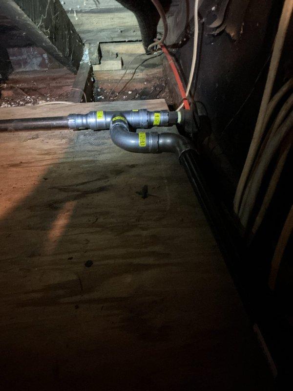 Replaced main gas line from meter in front yard to residential structure. Excavated trench from meter location to home using mechanical trencher, installed new gas line secured to exterior of building, and penetrated through garage overhang into attic space to connect with existing appliance feed lines serving boiler and water heater. Installed proper fittings and transitions in attic crawlspace to tie into existing distribution system. Backfilled excavated trench and allowed to settle. Conducted complete system pressure test to verify integrity of installation and confirmed no leaks present throughout entire gas line system.