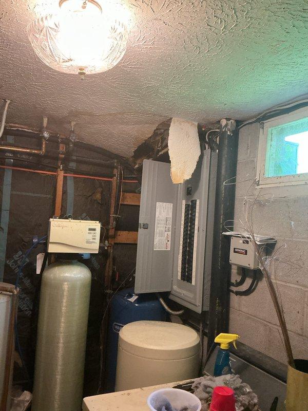 Responded to active water leak originating from upstairs toilet that was dripping through the ceiling into the basement utility room. Upon inspection, identified the source of the leak and assessed water damage to the basement ceiling and surrounding area. Performed necessary repairs to stop the active leak and prevent further water intrusion. Documented the mechanical room conditions, including existing water treatment systems, electrical panels, and plumbing infrastructure for reference. The leak was successfully resolved, and the affected area was left clean and dry.
