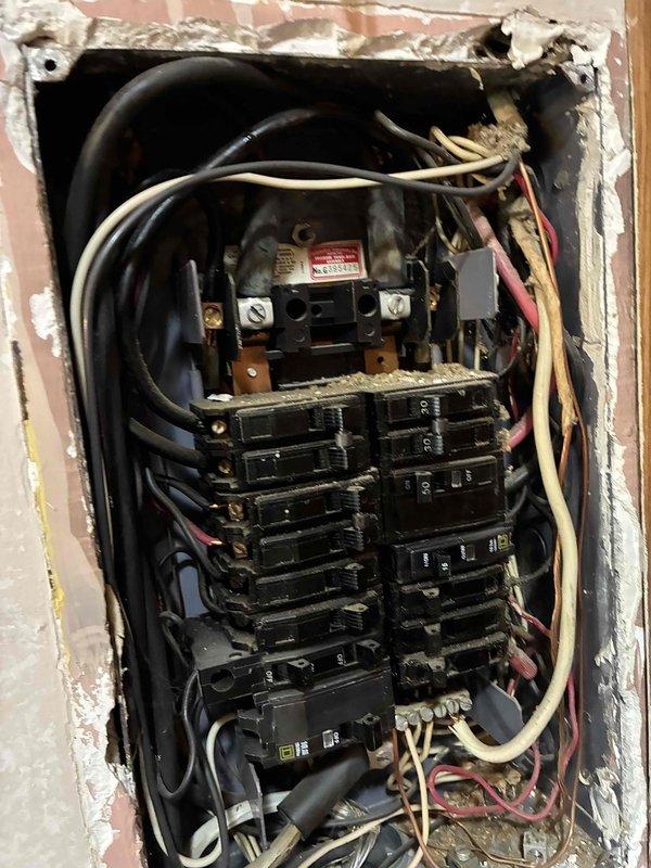 Conducted on-site evaluation of existing electrical panel and breaker box for potential upgrade. Inspected aged residential panel installation showing worn wiring connections, documented current panel configuration with dual-column circuit breaker arrangement, and assessed condition of main disconnect. Provided comprehensive estimate for panel replacement to meet current electrical code requirements and improve system safety.