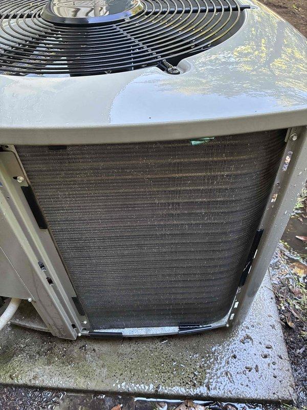 Completed MVP cooling maintenance visit on a 4-year-old residential air conditioning system. Upon inspection, found significant accumulation of dirt, dust, and environmental debris on the condenser coil fins, causing reduced airflow and heat transfer efficiency. Cleaned condenser coil thoroughly, removed access panel to access internal components, and documented unit condition with photos showing before-condition of heavily soiled coil surfaces and exterior components with visible weathering and discoloration.