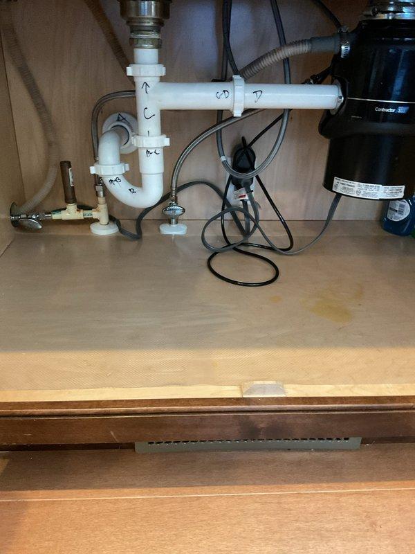 Responded to service call for clogged kitchen drain in residence with 12-year-old plumbing system. Upon inspection, confirmed blockage in kitchen sink drain line beneath cabinet. Successfully cleared obstruction using drain snake through P-trap assembly and drain line. Verified proper drainage flow and tested system to ensure complete clearance of blockage.