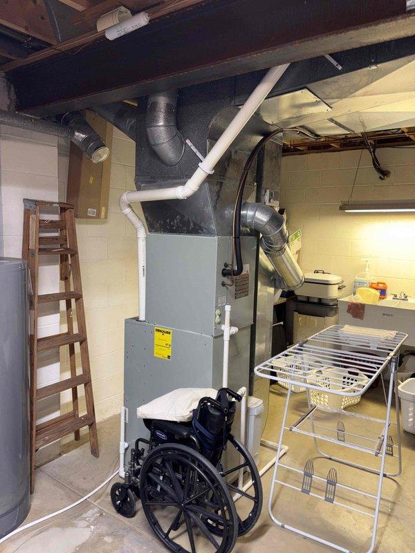 Conducted comprehensive furnace replacement estimate for residential basement installation. Assessed existing gray metal HVAC unit with white PVC venting system and evaluated ductwork connections, clearances, and accessibility requirements for future equipment replacement. Documented current system configuration including vertical venting arrangement and measured critical dimensions for proper sizing of replacement unit.