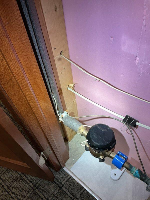 Provided consultation and information regarding automatic shut-off valve system installation for a 34-year-old residential property. Documented existing water meter configuration with copper supply lines, blue shut-off valve, and current plumbing infrastructure to assess feasibility and requirements for future automatic shut-off valve integration.