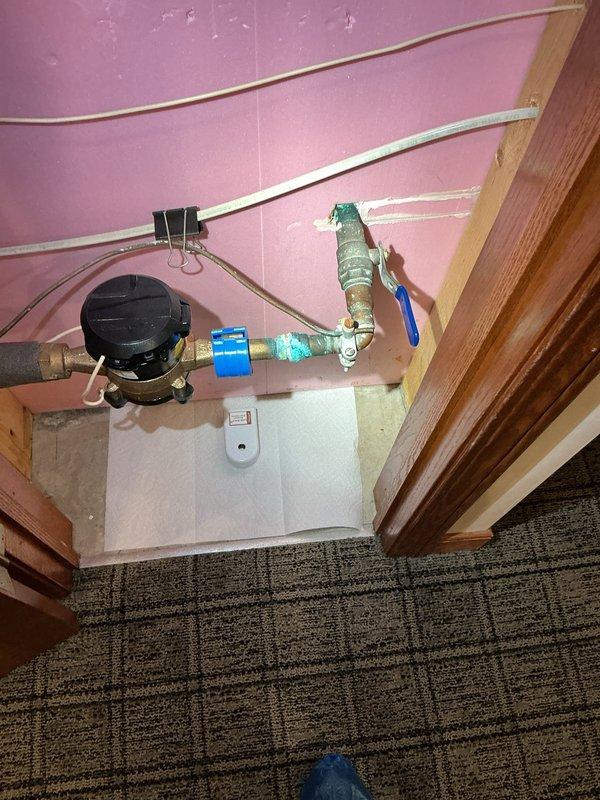 Provided consultation and information regarding automatic shut-off valve system installation for a 34-year-old residential property. Documented existing water meter configuration with copper supply lines, blue shut-off valve, and current plumbing infrastructure to assess feasibility and requirements for future automatic shut-off valve integration.