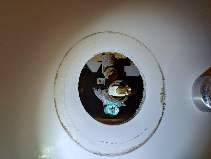 Responded to service call for leaking bathtub faucet. Upon inspection, discovered significant corrosion and mineral buildup on internal drain assembly components, including deteriorated metal brackets and oxidized brass fittings with rust staining around the fixture opening. Assessed all visible plumbing fixtures including tub spout, shower diverter, and drain components to determine source of leak and extent of deterioration requiring repair.