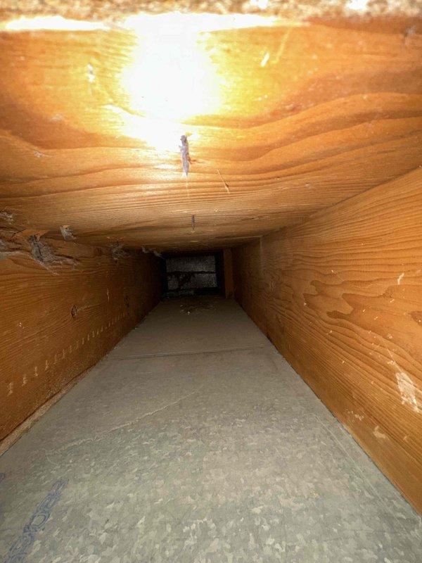 Completed comprehensive duct cleaning service for residential HVAC system covering up to 14 vents. Accessed ductwork through attic crawl space and removed significant accumulation of dust, debris, and lint from interior duct surfaces using specialized vacuum equipment. Heavy dust buildup was present on curved metal surfaces and horizontal sections where particles had settled over time, indicating system had not been serviced recently. Thoroughly cleaned all accessible ductwork, joints, and seams to restore proper airflow and improve indoor air quality. Documented pre-cleaning conditions showing extensive contamination throughout the system.