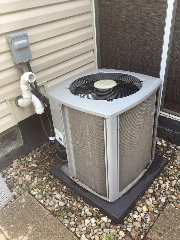 Completed comprehensive tune-up on 10-year-old residential air conditioning system. Performed standard maintenance procedures including inspection of condenser unit, electrical disconnect, and refrigerant lines. Evaluated concrete pad condition beneath outdoor unit as requested by customer and documented foundation area with gravel bedding, PVC condensate drain line with proper venting, and electrical connections to ensure system stability and proper drainage.