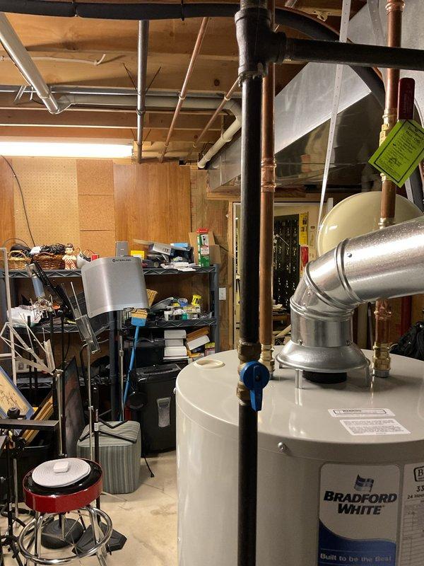 Completed installation of a 40-gallon tall Bradford White tanked water heater in basement utility area. Removed existing unit and installed new water heater with proper venting through metallic exhaust vent pipe, connected copper supply and distribution lines, and verified all plumbing connections were secure and leak-free. Unit was tested for proper operation and all safety systems confirmed functional.