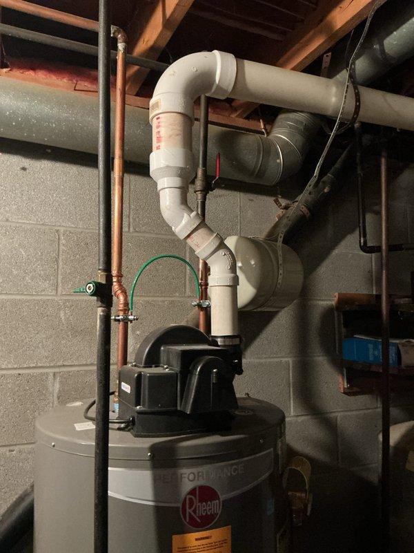 Responded to service call for leaking 6-year-old Rheem Performance tanked water heater in basement utility area. Upon inspection, identified active leak on unit and assessed water heater condition along with associated plumbing connections including copper supply lines, PVC piping, and pressure relief valve configuration. Documented equipment installation with photographic evidence showing water heater positioning, piping arrangement, and electrical connections for service records and future reference.