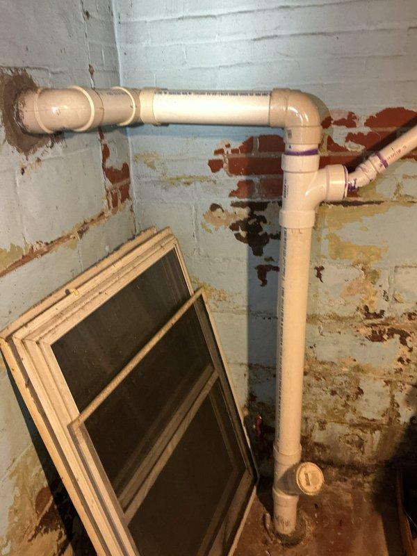 Responded to sewage backup in basement. Upon arrival, found multiple drainage points affected including three basement floor drains and one exterior lawn drain. Conducted diagnostic inspection of the drainage system to identify source of backup.

Visual inspection revealed severely corroded cast iron drain stack with extensive rust deterioration throughout the pipe interior and exterior surfaces. The vertical stack showed advanced corrosion with significant buildup of rust deposits and mineral scaling along interior walls, indicating long-term moisture exposure and structural compromise of the piping material. Concrete floor surrounding the drain exhibited staining consistent with chronic sewage seepage.

Additional inspection of basement drainage system revealed water damage and rust staining on concrete block walls near plumbing configuration, suggesting historical moisture intrusion issues. PVC drainage and venting system observed in upper wall area appeared to be later additions to