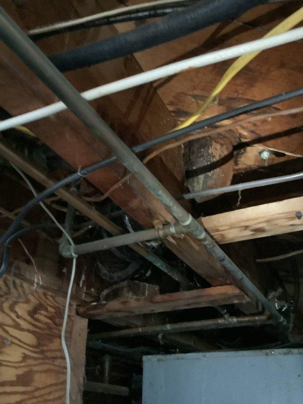 Responded to service call for bathtub drain blockage requiring snake service. Upon arrival, performed initial assessment of bathroom plumbing system and accessed drain line through tub overflow opening. Successfully deployed drain snake to clear obstruction in waste line, restoring proper drainage function. Inspected accessible plumbing infrastructure in crawl space above bathroom, documenting existing PVC waste lines, copper supply lines, and overall plumbing configuration for customer records.