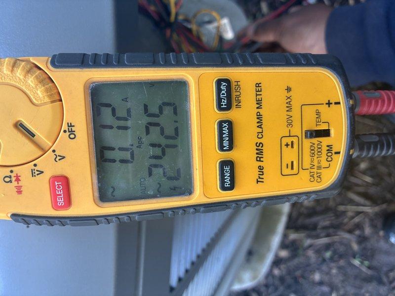 Completed scheduled maintenance visit on an 8-year-old air conditioning system. Performed comprehensive system inspection and testing of electrical components. Used digital multimeter to verify proper voltage readings and electrical performance, confirming system operating within manufacturer specifications at 24.5V control voltage. Inspected and tested capacitor assembly, checking all wire connections and terminal integrity. All electrical connections found secure with appropriate color-coded wiring intact. System operational and cooling effectively upon completion of maintenance procedures.