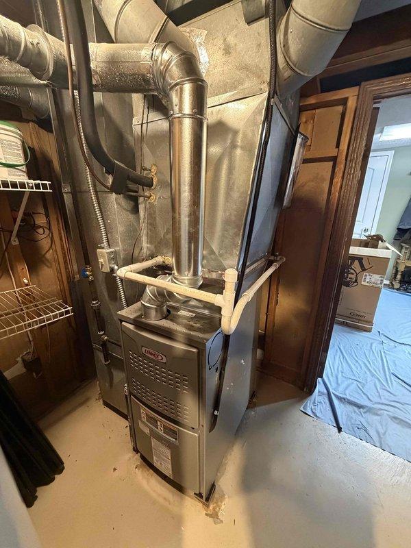 Installed new 80% efficiency Lennox furnace in basement utility area as first-stage heating system replacement. Connected unit to existing ductwork system with vertical supply plenum and horizontal distribution runs, installed carbon monoxide alarm in mechanical room per safety code requirements, and verified proper clearances and operational functionality of complete system.