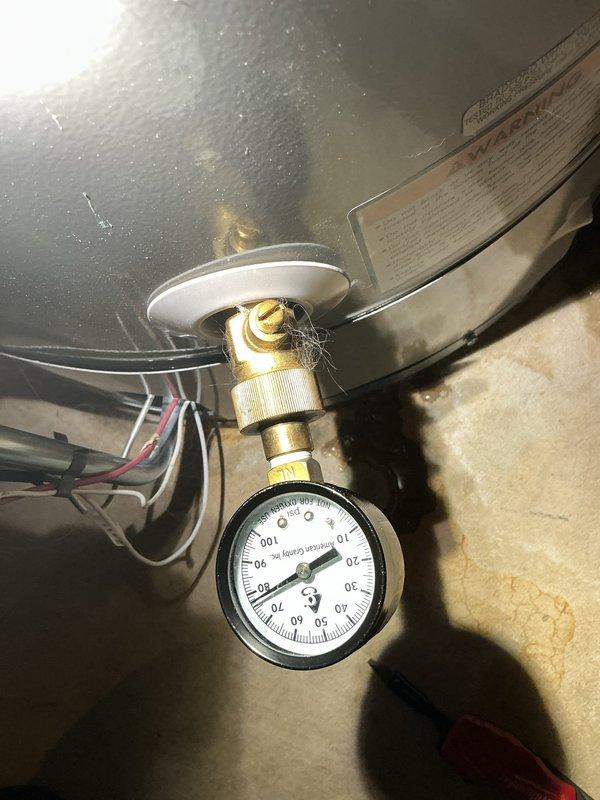 Responded to service call for leaking water tank in 27-year-old residential property. Upon inspection, identified leak originating from pressure tank assembly and associated brass fittings in basement utility area. The existing expansion tank, which had been in service for approximately eight years, showed signs of failure at connection points. Evaluated pressure gauge readings and tested system integrity. Addressed leak source, inspected copper piping and PEX water line connections, and verified proper drainage catchment was in place beneath plumbing assembly to prevent water damage.