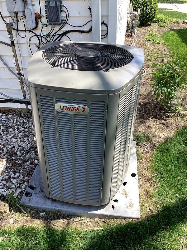 Responded to service call for hail damage assessment on 3-year-old Lennox AC condenser unit. Performed comprehensive inspection of outdoor unit following recent hail storm that damaged condenser stand. Evaluated unit exterior panels, louvers, fan guard, and all visible components for hail impact damage. Inspected concrete pad and mounting stand, noting holes and structural damage to stand requiring repair. Checked refrigerant lines, electrical connections, and service ports for any storm-related damage. Tested unit operation, verified proper airflow through louvers, and confirmed fan motor function. Documented equipment condition with photographs showing unit placement, surrounding landscape debris accumulation, and weathered concrete pad. Unit operational with no immediate safety concerns identified from hail damage.