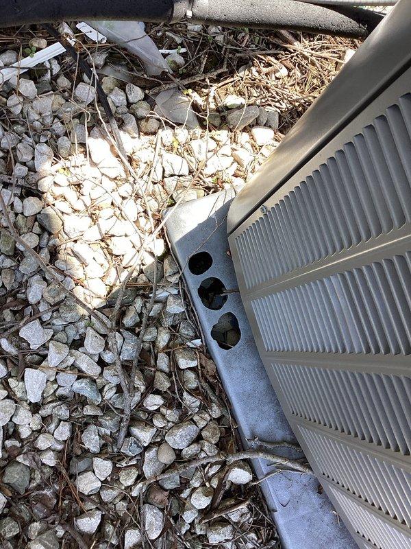 Responded to service call for hail damage assessment on 3-year-old Lennox AC condenser unit. Performed comprehensive inspection of outdoor unit following recent hail storm that damaged condenser stand. Evaluated unit exterior panels, louvers, fan guard, and all visible components for hail impact damage. Inspected concrete pad and mounting stand, noting holes and structural damage to stand requiring repair. Checked refrigerant lines, electrical connections, and service ports for any storm-related damage. Tested unit operation, verified proper airflow through louvers, and confirmed fan motor function. Documented equipment condition with photographs showing unit placement, surrounding landscape debris accumulation, and weathered concrete pad. Unit operational with no immediate safety concerns identified from hail damage.