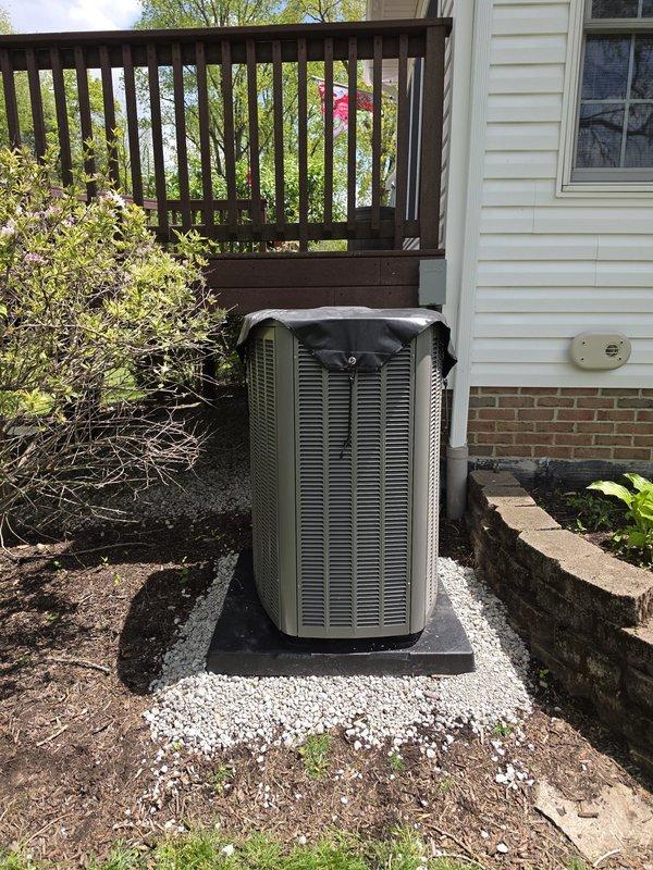 Returned to complete air conditioning installation by leveling the outdoor condenser unit on its concrete pad. Used torpedo level to verify proper alignment and adjusted unit positioning to ensure stable, level placement for optimal operation and drainage.
