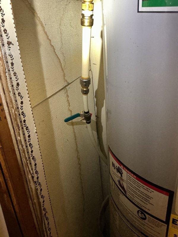 Conducted on-site assessment for tankless electric water heater installation in manufactured home. Evaluated existing electric storage tank water heater system, documented current plumbing configuration including PVC supply lines with brass compression fittings and shut-off valve, and assessed electrical requirements for conversion from conventional storage unit to tankless system. Photographed existing installation to determine necessary modifications for tankless unit compatibility and provided comprehensive estimate for equipment and installation.
