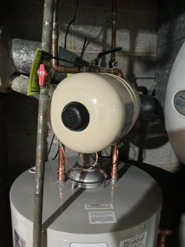 Replaced existing water heater with a new Bradford White 40-gallon short model featuring a 10-year manufacturer warranty. Installation included adding a thermal expansion tank to protect against pressure buildup in the closed plumbing system and bonding the hot and cold water lines to meet current electrical safety codes. All necessary parts were staged prior to installation. The unit was installed in the basement utility area with proper copper piping connections, shutoff valves, and pressure relief valve. The expansion tank was mounted above the water heater using appropriate support brackets and connected to the cold water supply line. Electrical bonding was completed between hot and cold water lines using approved grounding methods to ensure system safety and code compliance.