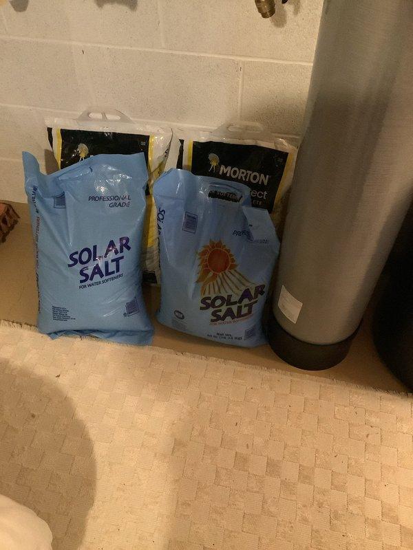 Delivered and stocked water softener salt supply to utility room. Placed multiple bags of solar salt adjacent to water softener tank and refilled brine tank with salt pellets to ensure proper system operation and continuous water treatment capability.