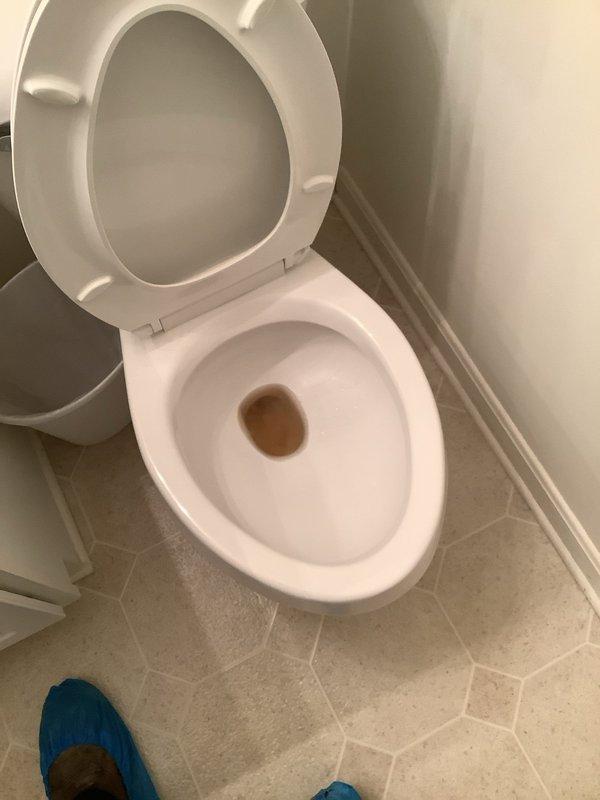 Responded to service call for clogged first-floor toilet at residential property. Upon arrival, inspected white porcelain two-piece toilet and confirmed blockage preventing proper drainage. Successfully cleared obstruction from toilet bowl using appropriate plumbing tools and techniques, restoring full functionality and proper water flow to the fixture.