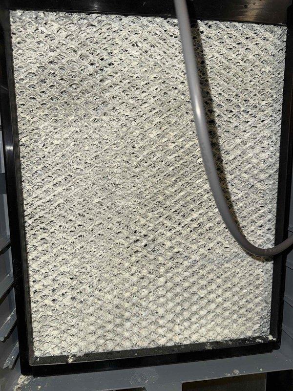 Completed scheduled cooling maintenance visit on HVAC system. Inspected air filter showing moderate dust accumulation with visible discoloration across mesh surface, and examined blower wheel assembly which displayed significant dust and debris buildup on metal blades and housing. System components photographed and documented for maintenance records.