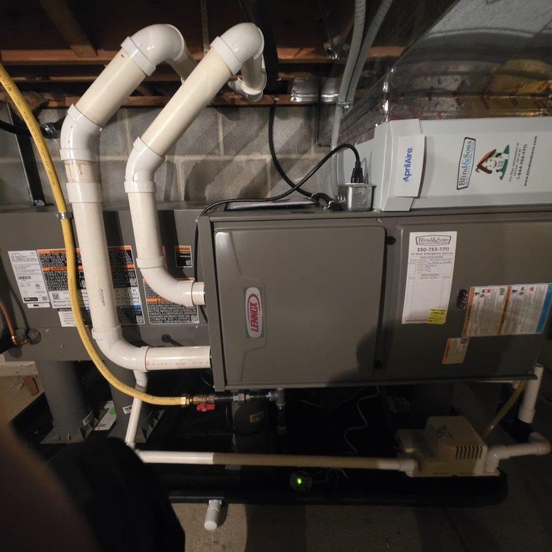 Responded to warranty call for newly installed air conditioning system producing abnormal loud noise upon startup. Performed comprehensive inspection of Lennox HVAC system including furnace, air handler, and associated components. Verified proper installation of intake and exhaust venting, gas line connections, and electrical wiring. Inspected AprilAire humidifier and ductwork connections for secure mounting and potential vibration sources. Documented system configuration with photographs showing complete installation layout. System evaluated for loose panels, unsecured components, or improper mounting that could cause operational noise during AC startup cycle.