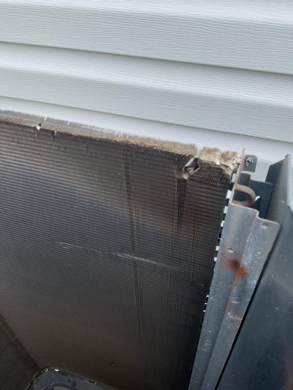 Completed MVP cooling maintenance visit on residential air conditioning system. Upon inspection, found substantial dirt, dust, and debris accumulation on condenser coils with thick buildup of fibrous material along the top edge of fins, restricting airflow and reducing heat transfer efficiency. Accessed internal compartment to inspect electrical components including capacitor, compressor connections, and associated wiring. All electrical connections verified secure with proper wire routing observed. Documented pre-service condition of heavily soiled condenser coils and internal component configuration through photographic evidence. Unit showed signs of extended operation without routine maintenance based on level of contamination present on heat exchange surfaces.