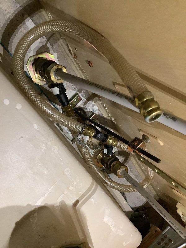 Responded to leaking faucet issue in 20-year-old home with Moen two-handle bathroom fixtures. Diagnosed failed flexible supply line with broken plastic end fitting causing water flow between handles. Replaced damaged braided stainless steel supply line with new flexible connector and installed functional shut-off valves under sink to provide proper water control. Verified all connections secure, tested for leaks, and confirmed proper operation of faucet assembly upon completion.