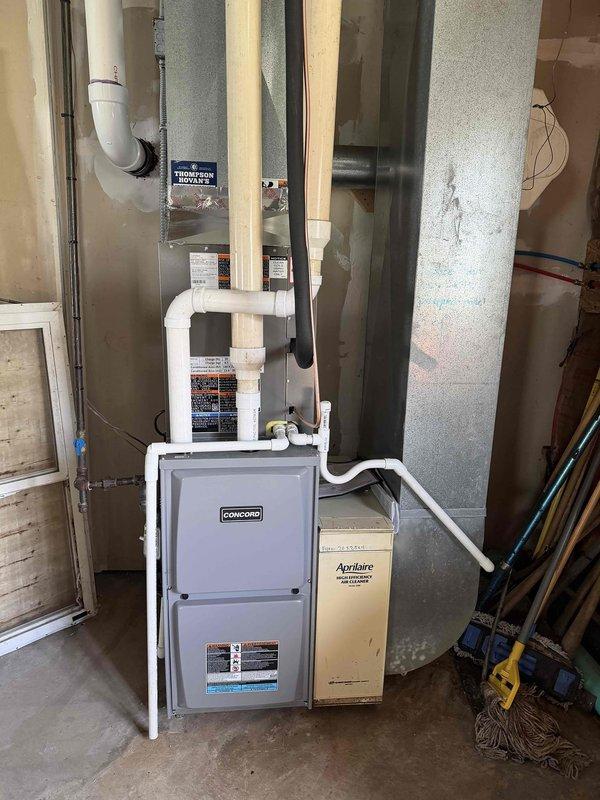 Completed installation of multi-unit HVAC system for duplex property, including 3-ton air conditioning unit with evaporator coil for downstairs unit and 2.5-ton system for upstairs unit. Installed Concord furnace with integrated ductwork, white PVC condensate drainage lines, and Aprilaire humidification system in basement utility area. All equipment properly mounted, connected to existing ductwork infrastructure, and tested for proper operation. Additional mobile home units scheduled for subsequent installation phase.