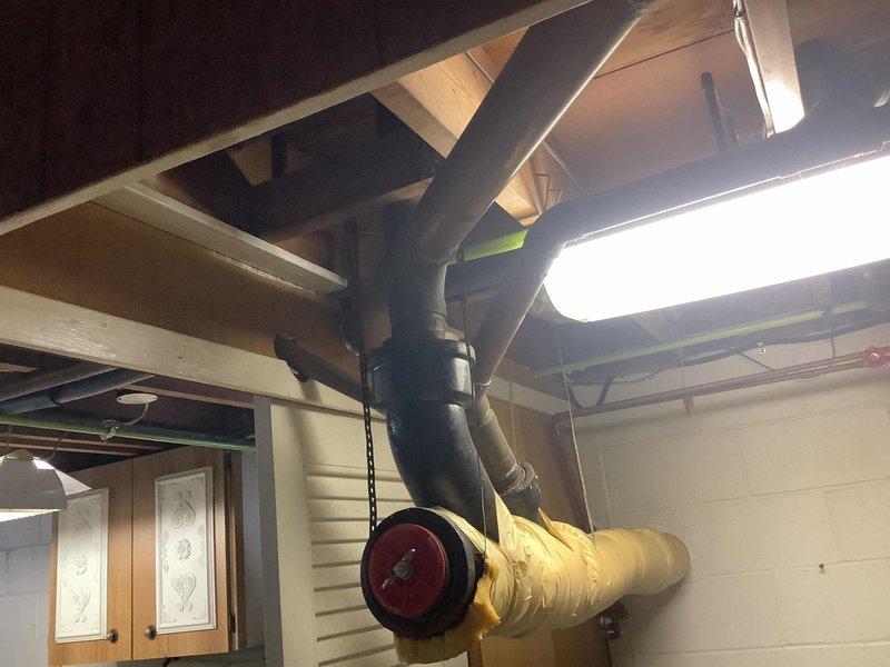 Completed comprehensive plumbing assessment of residential property with original 1958 plumbing system in preparation for sale. Inspected and documented all accessible plumbing infrastructure including basement utility areas, exposed piping systems, water heater installation, and drainage components. Observed yellow-insulated piping, PVC drain lines with multiple fittings, copper supply lines, and evidence of previous water staining on utility room flooring indicating potential past leak history that should be disclosed to prospective buyers.