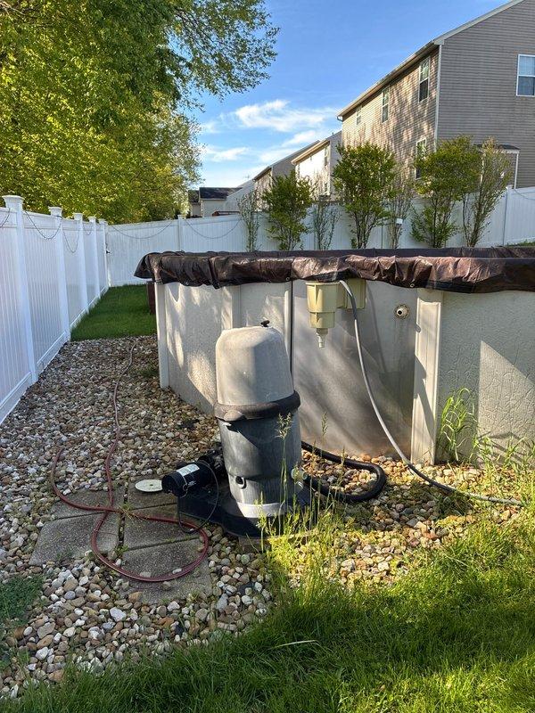 Installed electrical conduit from main service panel to above-ground pool equipment area to replace temporary extension cord setup. Ran weatherproof conduit along exterior of residence, terminating at dedicated pool equipment disconnect near filter and pump system positioned adjacent to pool on gravel pad.