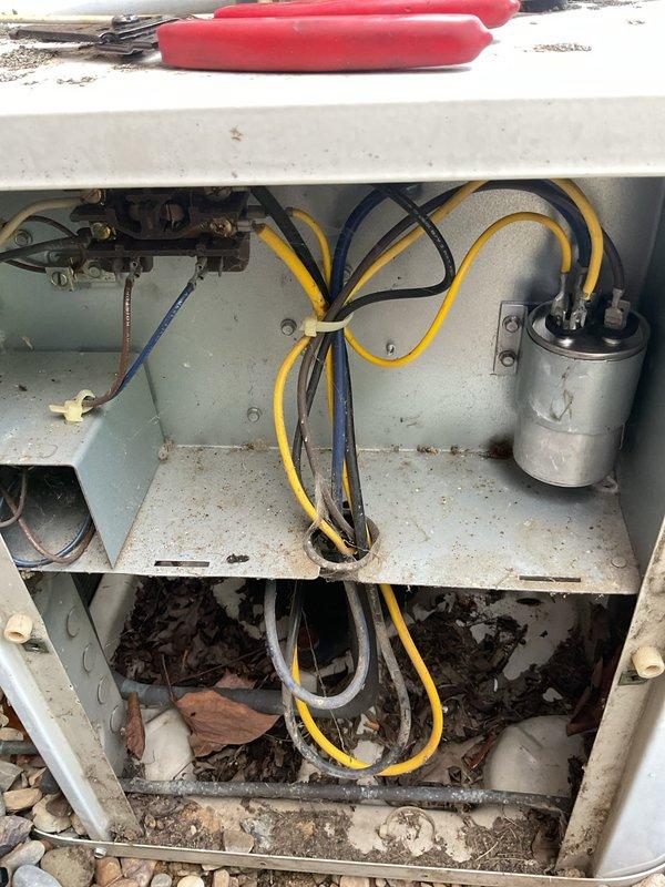 Performed preventative maintenance on 15+ year old air conditioning system. Cleaned outdoor condenser unit which had significant debris accumulation including leaves, twigs, and nesting material in the compartment; inspected electrical components including capacitor and wiring connections; verified proper operation of all system components.